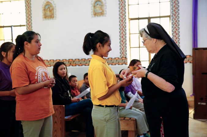 Franciscan sister distributes Communion during weekday Mass at St. Peter Indian Mission School in Arizona